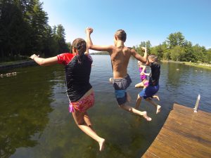 People jumpingoff a dock in to the Connecticut River